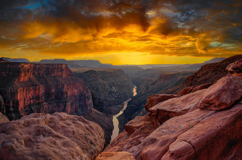 View from a rocky cliff of the Grand Canyon Arizona overlooking the Colorado River below at sunset